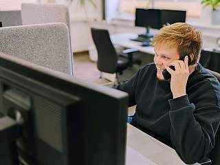 Auszubildender im Bürobereich telefoniert mit einem Kunden